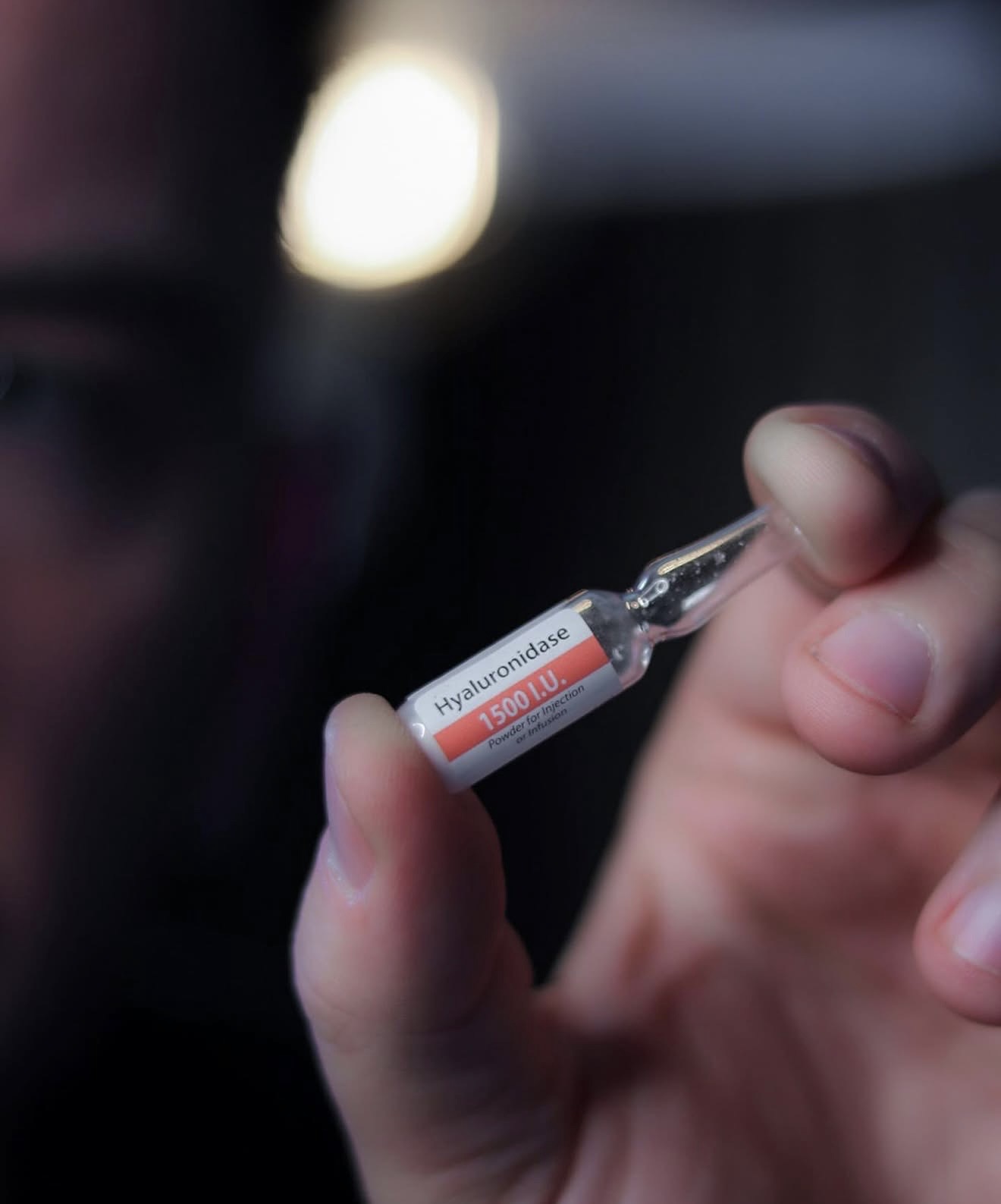 Brad holding a 1500 I.U. Hyaluronidase ampoule under a warm clinic light
