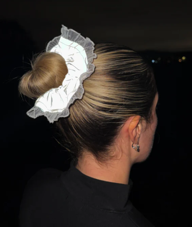 Reflective hair scrunchie by Eve Marmalade catching light against a dark background