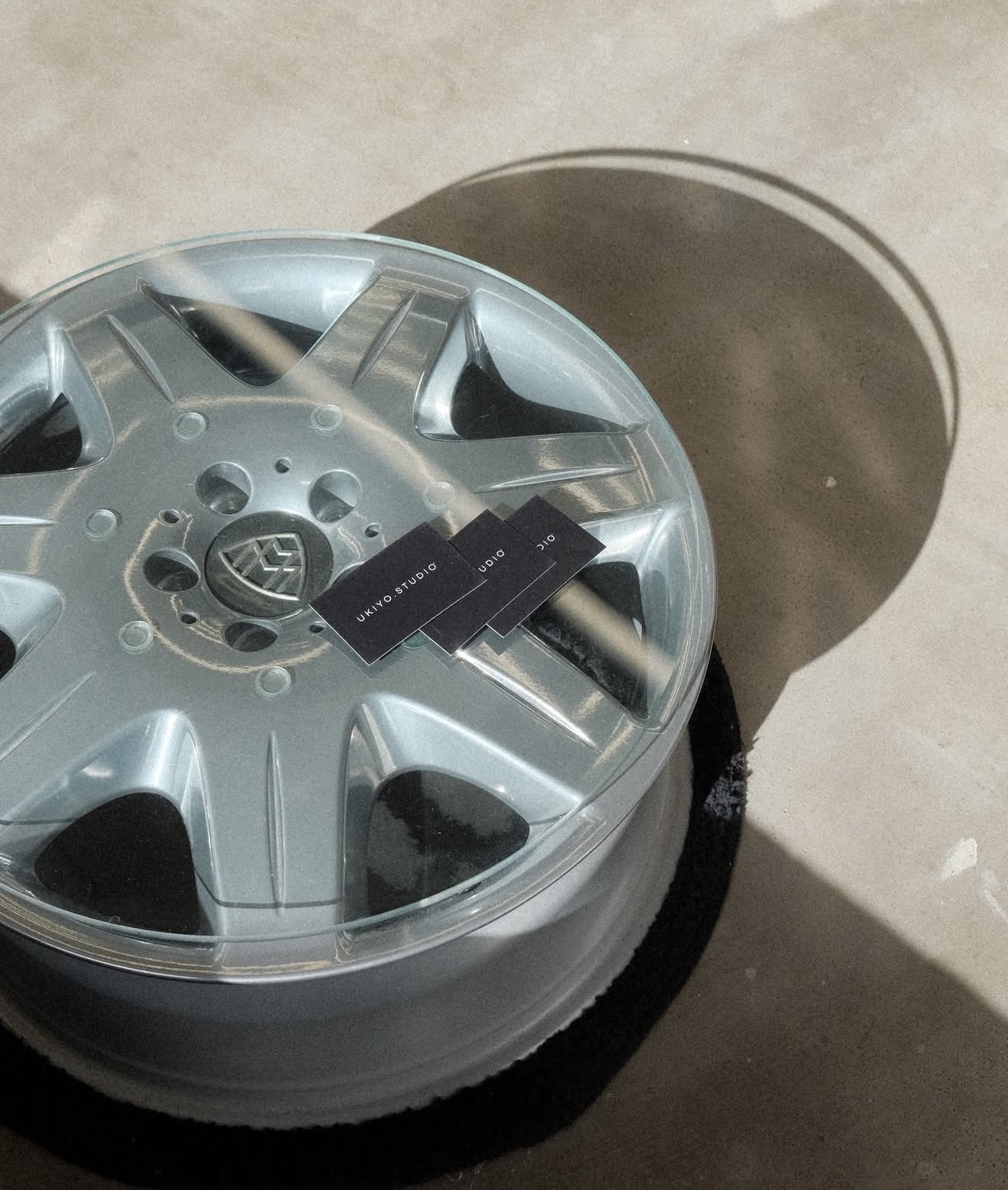 UKIYO.STUDIO business cards resting on a polished alloy wheel coffee table